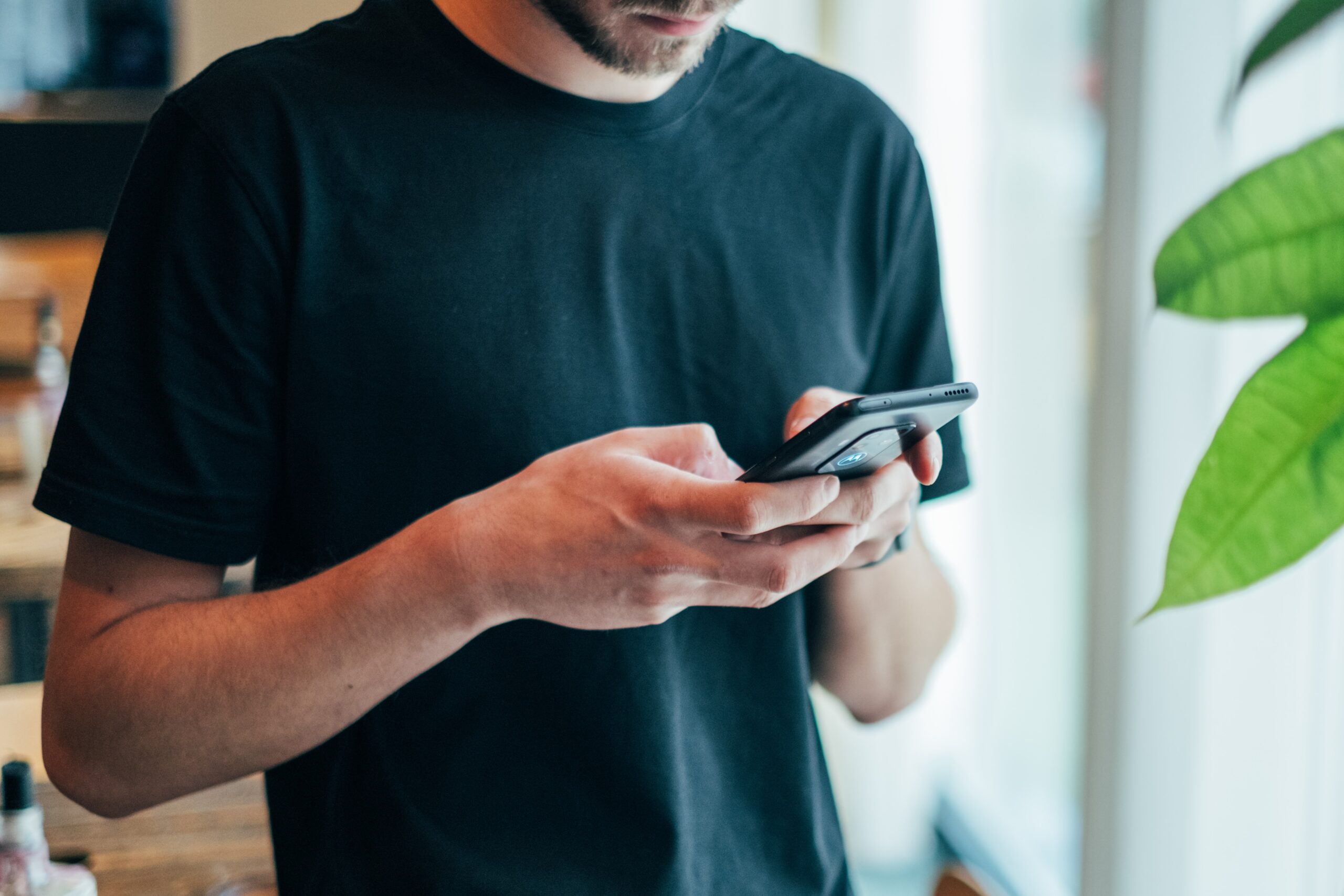 A man in black shirt using his phone.